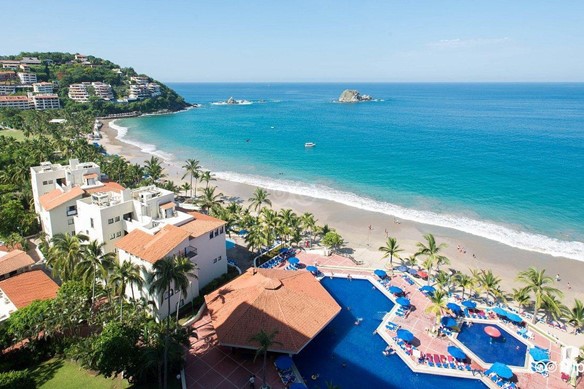 Vista de hotel frente al mar turquesa durante un día despejado y soleado.